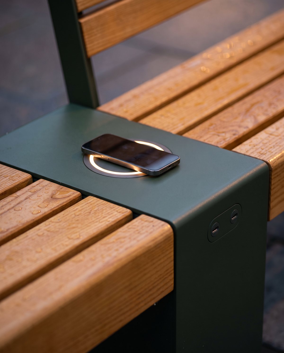 Phone charging on the wireless pad in the bench armrest, beside two USB-C ports